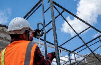 construction worker wearing safety harness and safety line with tools